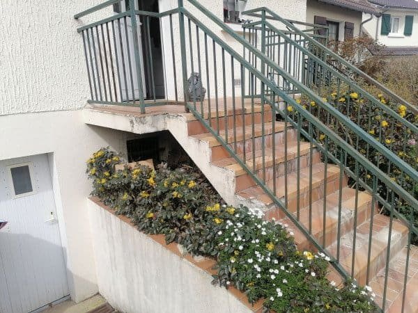 Porte d'entrée avec escalier extérieur et jardin fleuri, travaux de construction et rénovation par G.