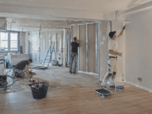 Travailleurs en train de poser des cloisons dans un projet de rénovation intérieure.