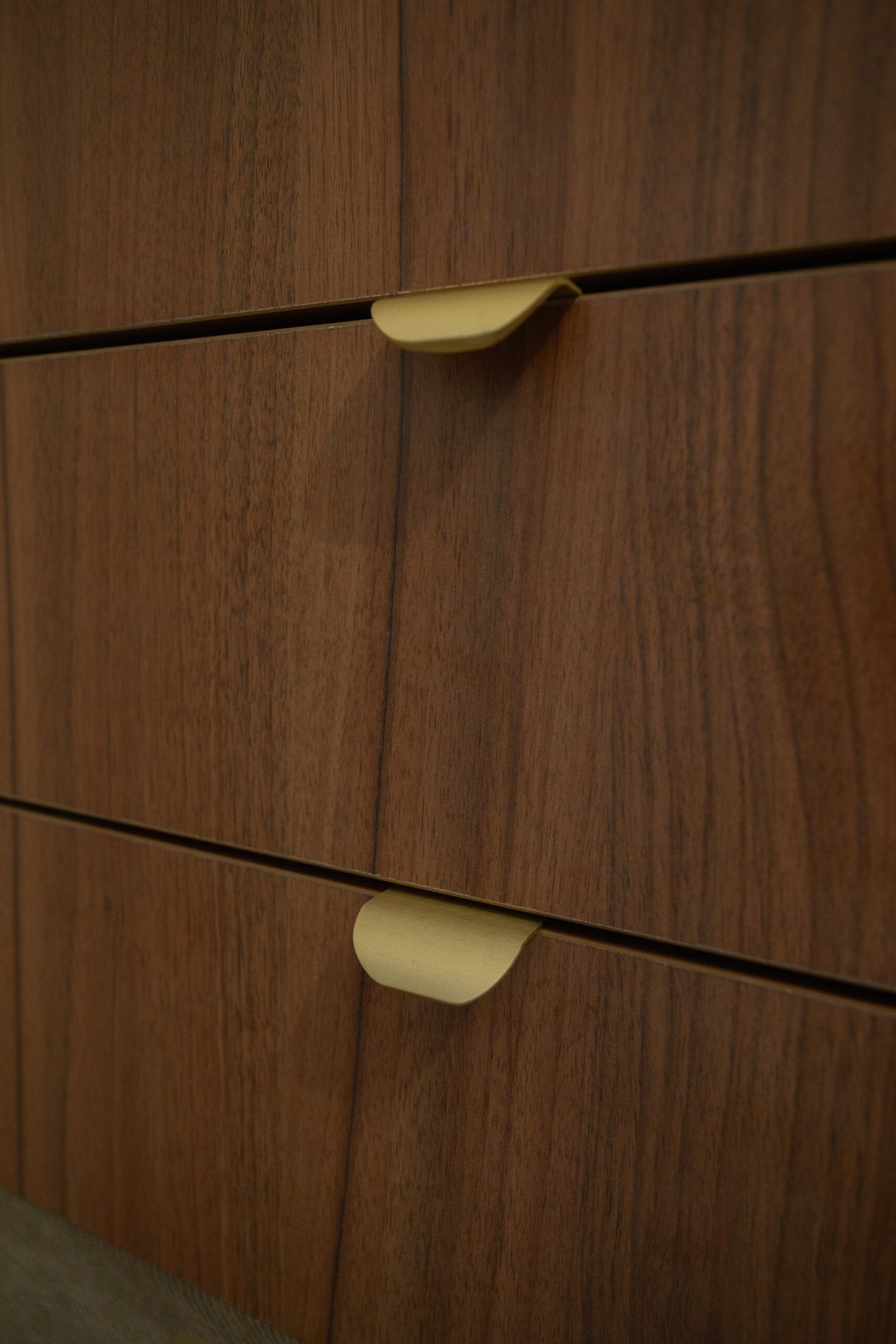 Détail des poignées finition laiton sur le meuble de salle de bain