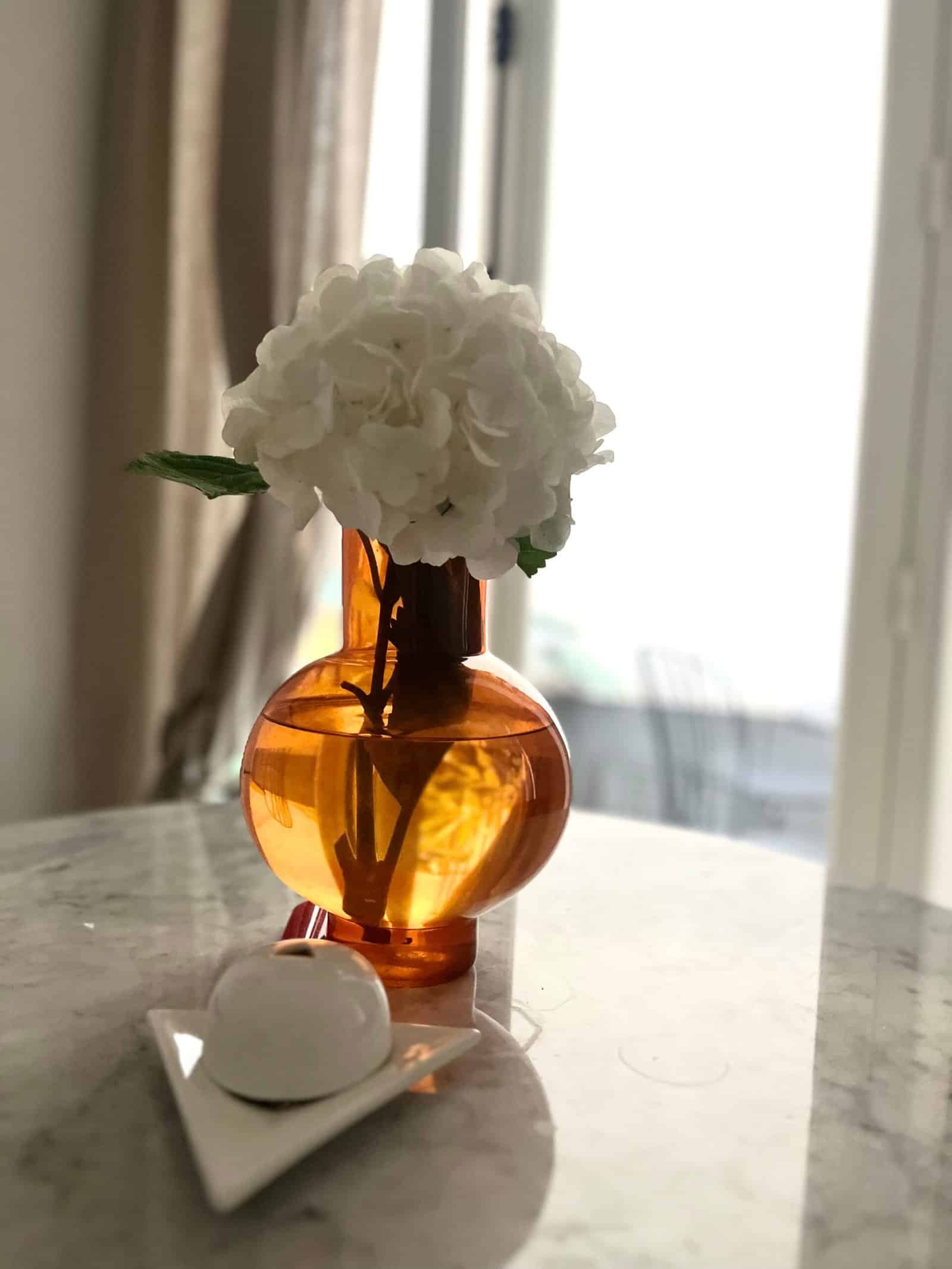 Vase en verre ambré avec fleurs blanches, décoration intérieure élégante.
