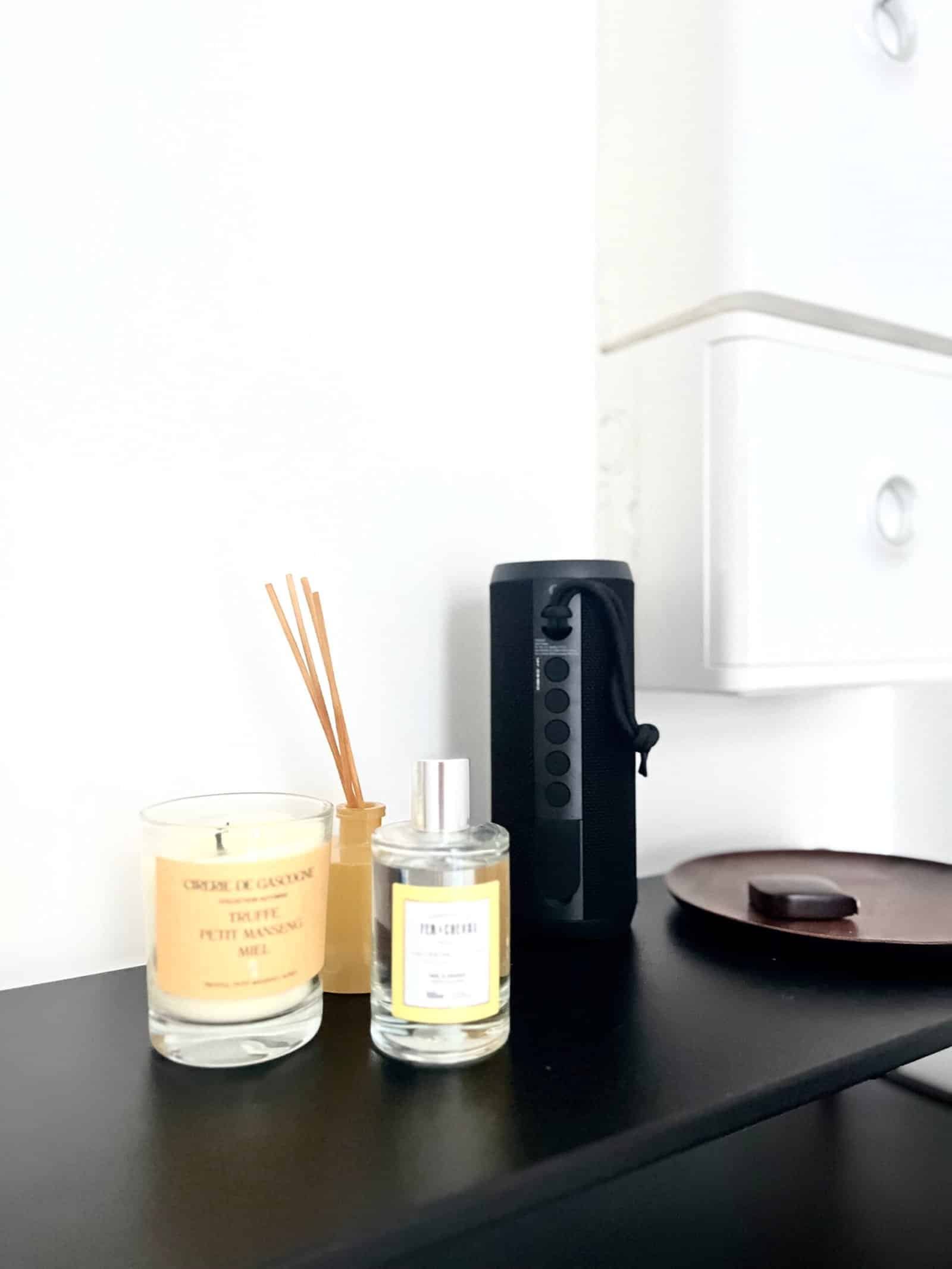 Vase parfumée et diffuseur d'ambiance modernes sur une surface noire.