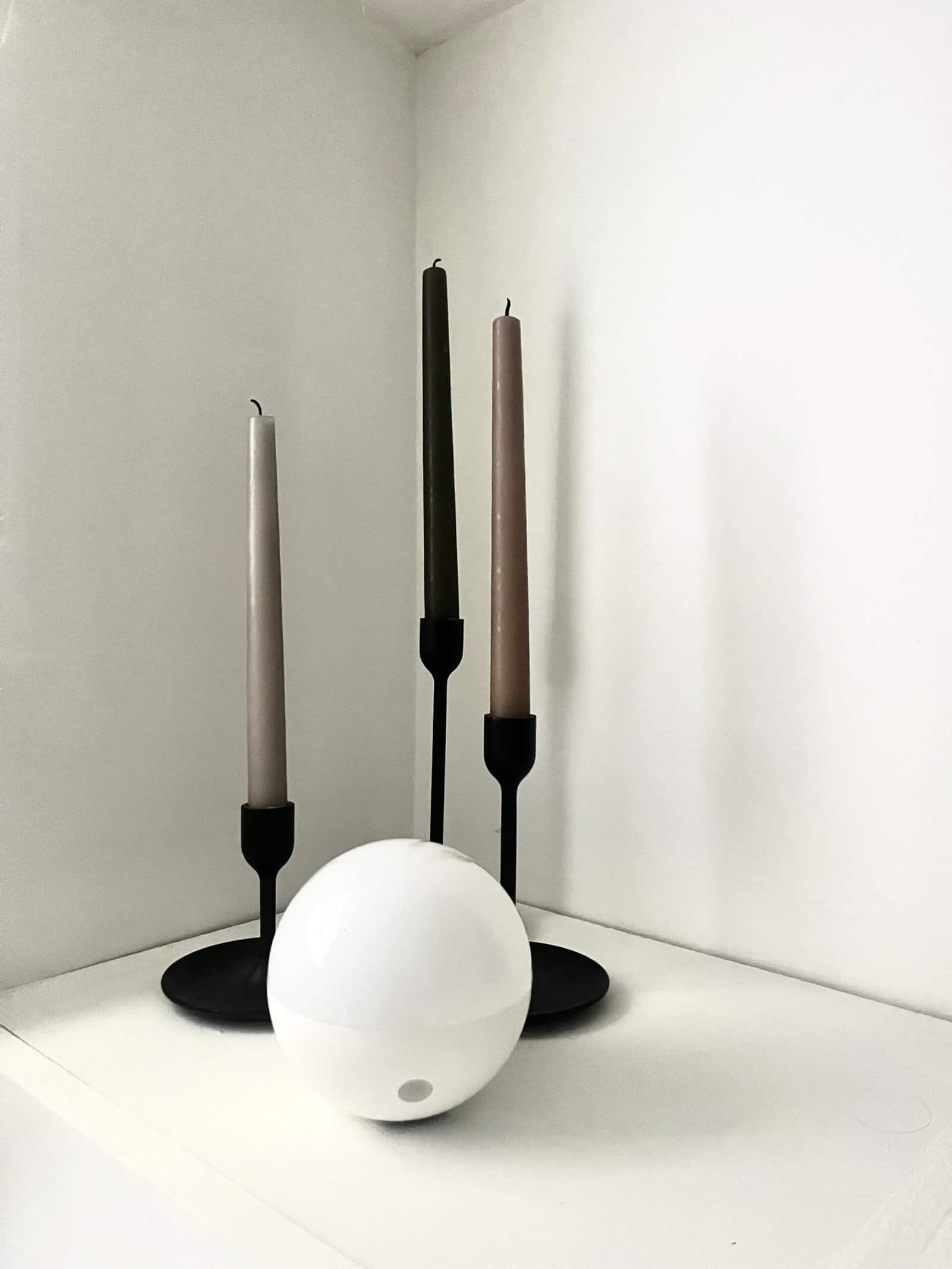 Bougies colorées et boule lumineuse pour décoration intérieure élégante.