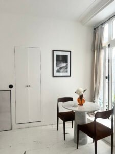 Balcon lumineux avec table en marbre et chaises confortables, idéal pour repas en famille ou entre a.