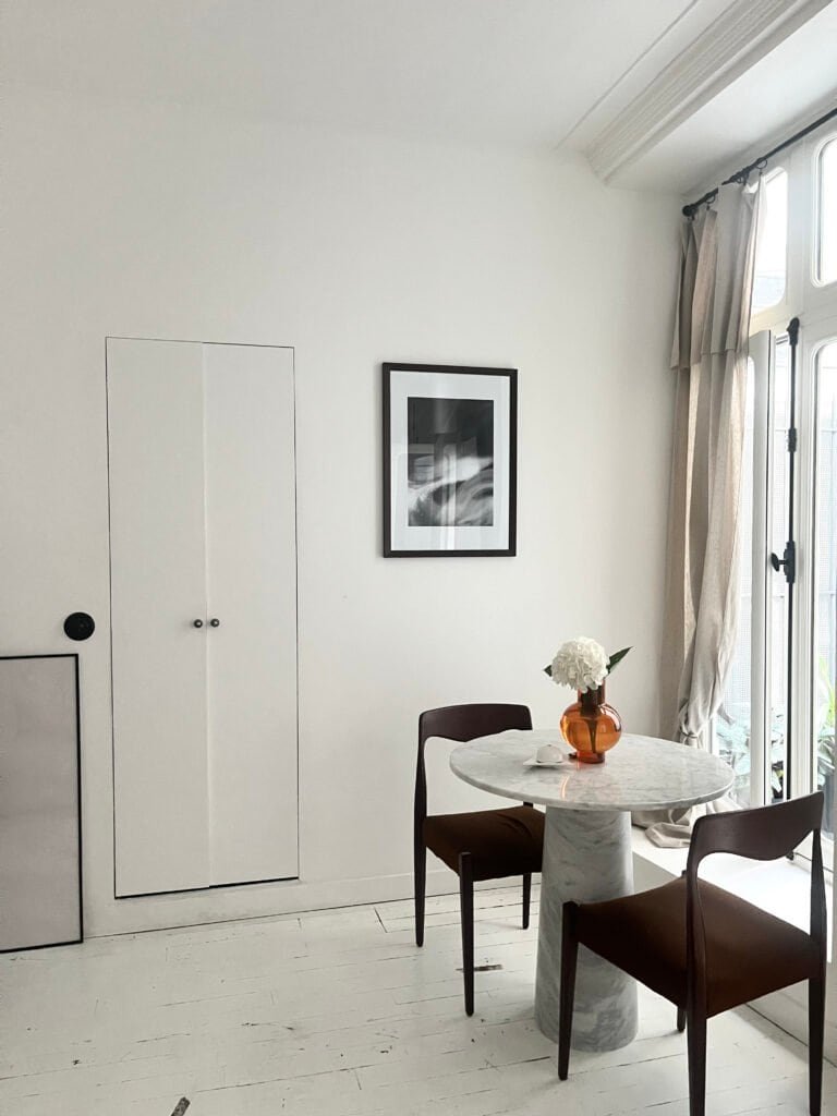 Balcon lumineux avec table en marbre et chaises confortables, idéal pour repas en famille ou entre a.