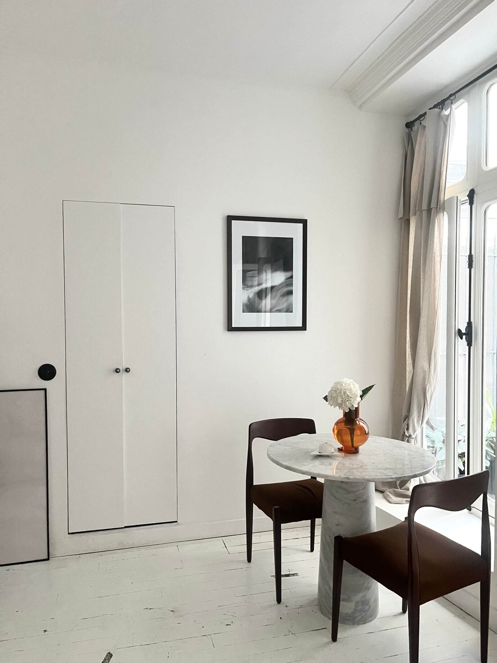 Balcon lumineux avec table en marbre et chaises confortables, idéal pour repas en famille ou entre a.