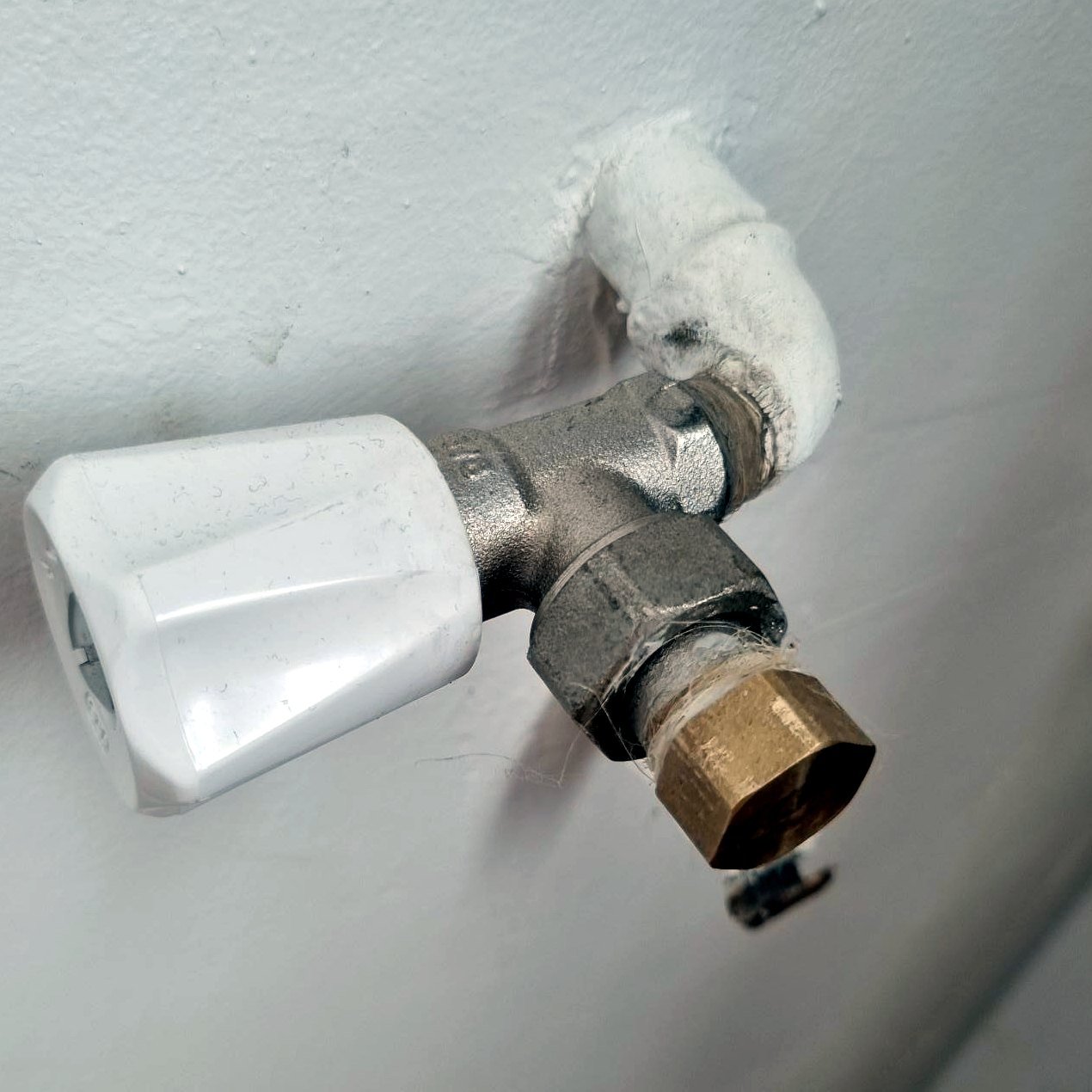 Ancien robinet de radiateur manuel avant modification des raccordements de plomberie